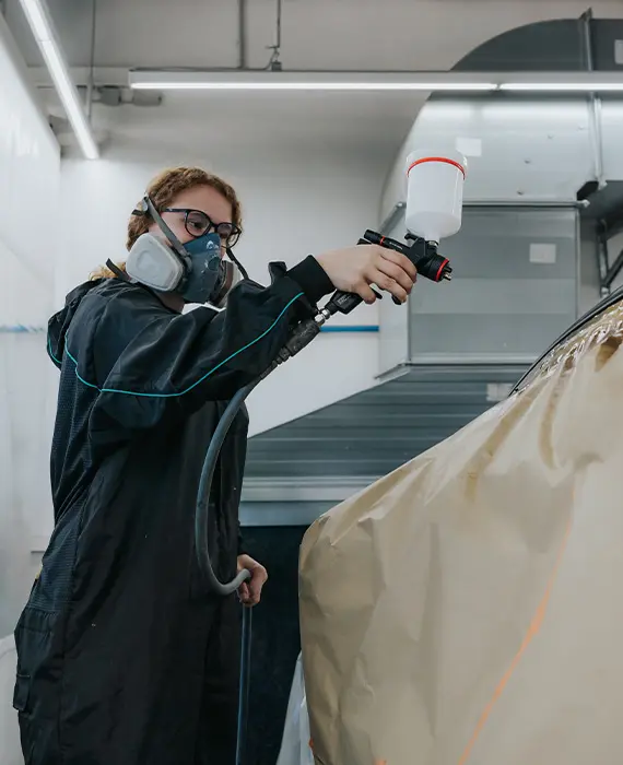 Mitarbeiter besprüht ein Auto